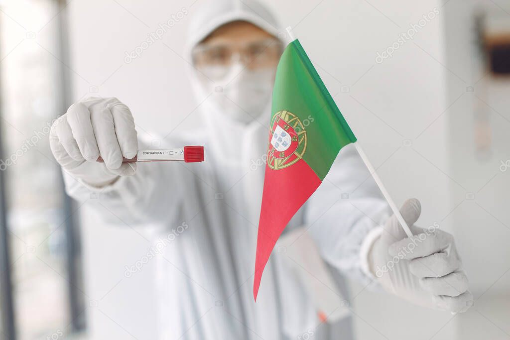 The scientist in coverall suit with a coronavirus sample and Portuguese flag