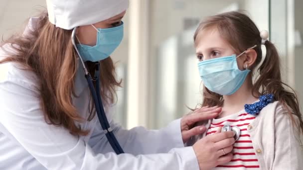 A mulher médica está examinando uma criança com estetoscópio — Vídeo de Stock