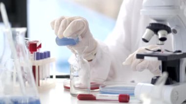 Scientist in coverall suit is making coronavirus test in a lab