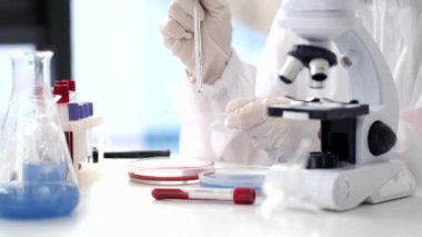 Scientist in coverall suit is making coronavirus test in a lab