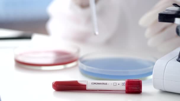 Ученый в комбинезоне делает коронавирусный тест в лаборатории — стоковое видео