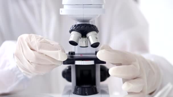 Un chercheur scientifique ajuste un microscope dans un laboratoire — Video