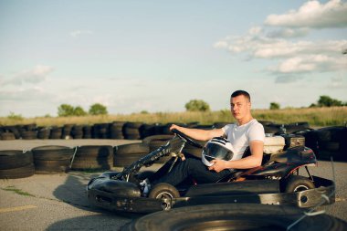 Handsome man in a karting with a car