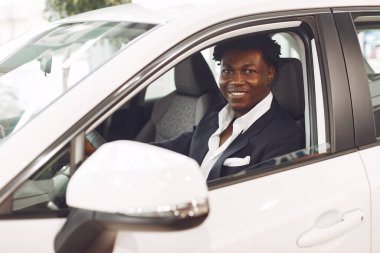 Yakışıklı ve zarif bir siyah adam bir araba salonunda.