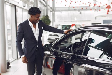 Yakışıklı ve zarif bir siyah adam bir araba salonunda.