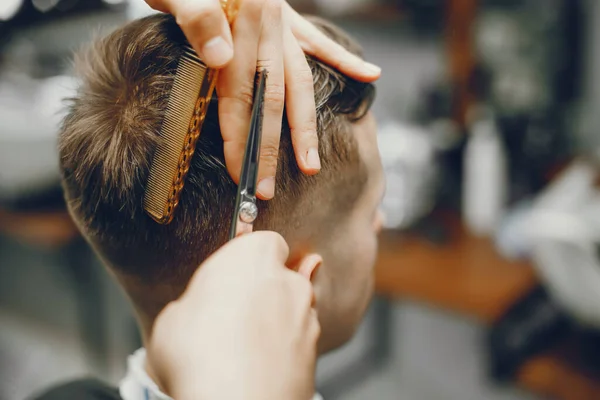 Un hombre corta el pelo en una barbería —  Fotos de Stock