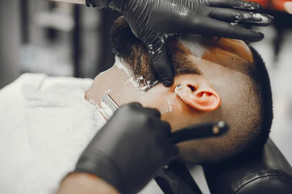 O homem corta a barba na barbearia — Fotografia de Stock