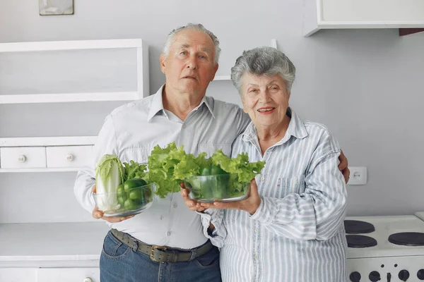 Hermosa pareja de edad preparar la comida en una cocina —  Fotos de Stock