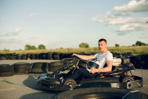 Knappe man in een karting met een auto — Stockfoto