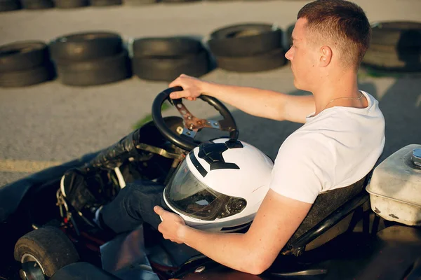 Hombre guapo en un karting con un coche — Foto de Stock