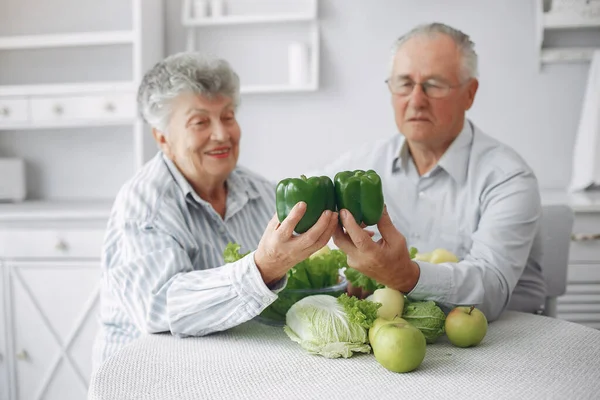 Beautiful old couple prepare food in a kitchen Stock Image