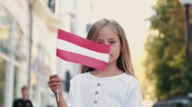 Dışarıda ülkeyi temsil eden Avusturya bayrağı tutan bir kız.