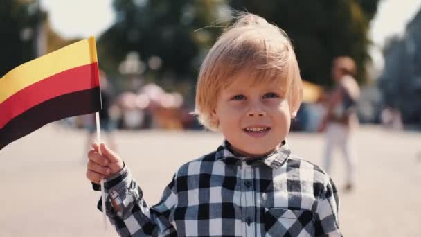 Niño sosteniendo bandera alemana en el centro de la ciudad — Vídeos de Stock