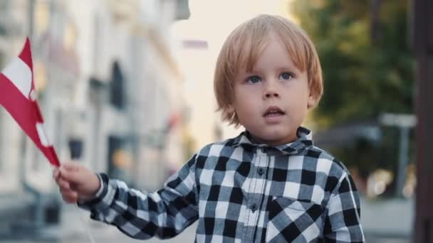 Μικρό αγόρι με ξανθά μαλλιά κρατώντας Αυστριακή σημαία — Αρχείο Βίντεο