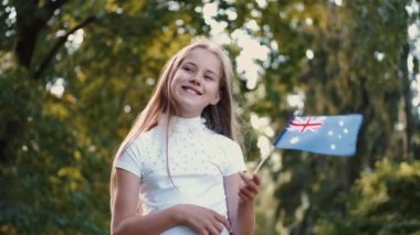 Parkta İngiliz bayrağı taşıyan gülümseyen kızın portresi