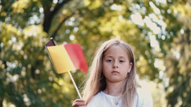 Şehir parkında elinde bayrak tutan sarışın kızın portresi. — Stok video