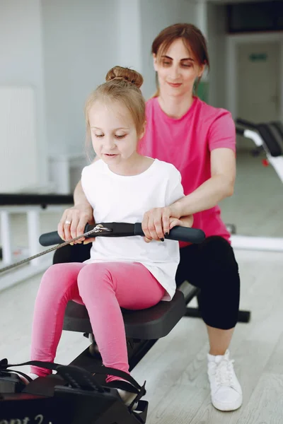Mother with little daughter are engaged in gymnastics in the gym — Stock Photo, Image