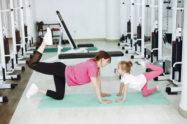 Mother with little daughter are engaged in gymnastics in the gym — Stock Photo, Image