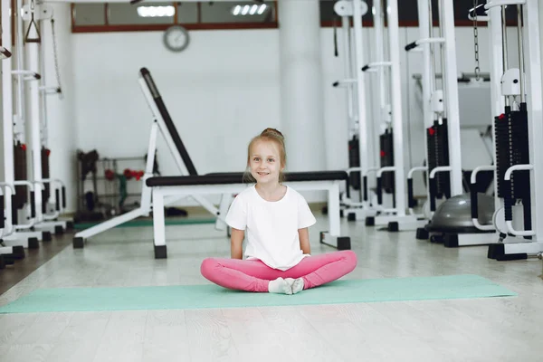 Cute little girl are engaged in gymnastics in the gym — Stock Photo, Image