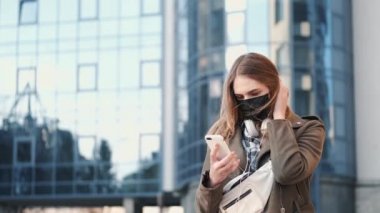 Tırpancının yanında akıllı telefonu olan genç bir bayan siyah solunum cihazı takıyor.