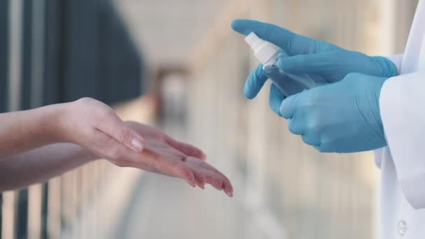 Medicina uomo sta spruzzando antisettico sulle mani delle donne — Video Stock