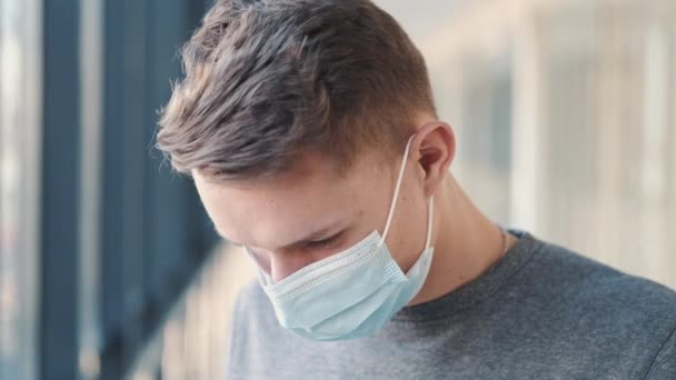 Een Europese man met een masker voelt zich van streek. — Stockvideo