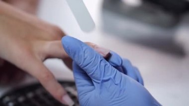 Güzellik uzmanının ellerinin yakın plan çekimleri kadın müşteriler için manikür yapıyor.