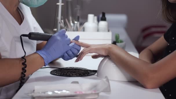 Close-up of beautician hands cleaning female clients nails — Stock Video