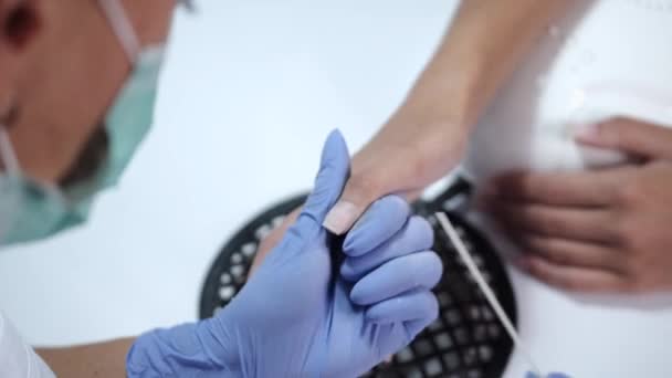 Nahaufnahme der Hände einer Kosmetikerin, die Maicure für eine Kundin herstellt — Stockvideo