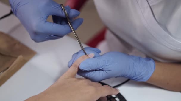 Gros plan de l'esthéticienne mains nettoyage des ongles à l'aide de ciseaux — Video