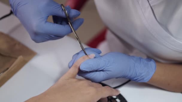 Primer plano de manos esteticistas limpiando uñas usando tijeras — Vídeo de stock