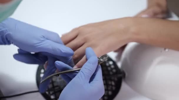 Zbliżenie kosmetyczka ręce czyszczenie paznokcie za pomocą nożyczek — Wideo stockowe
