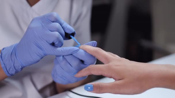 Close-up de mãos esteticistas fazendo manicure azul para o cliente — Vídeo de Stock