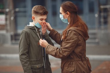 A boy and mother are wearing protective masks