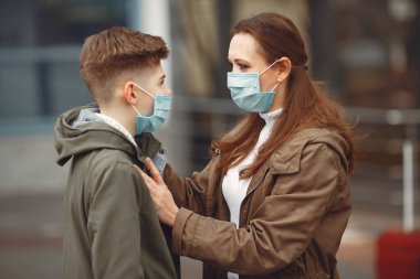 A boy and mother are wearing protective masks