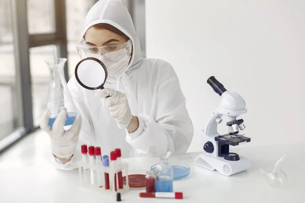 Een laboratoriumwetenschapper onderzoekt blauwe oplossing in een fles — Stockfoto