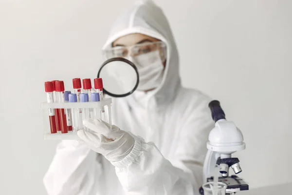 Wetenschapper in coverall kleding onderzoekt coronavirus monster in een laboratorium — Stockfoto