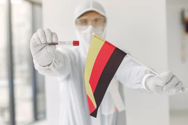 身穿覆盖服的科学家带着验尸报告样本和德国国旗 — 图库照片