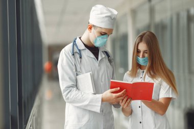 Maskeli doktorlar sorunu koridorda tartışıyorlar.