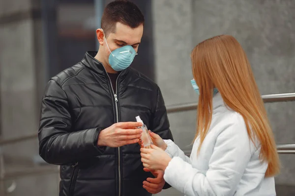 Los jóvenes que usan máscaras protectoras están rociando desinfectante para las manos —  Fotos de Stock