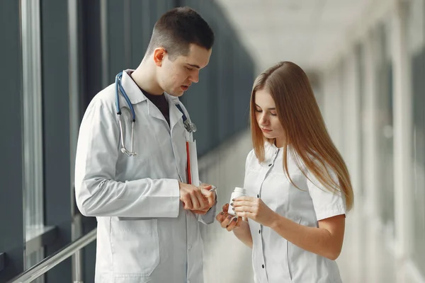 Doutor está compartilhando pílulas nas mãos de outro médico — Fotografia de Stock