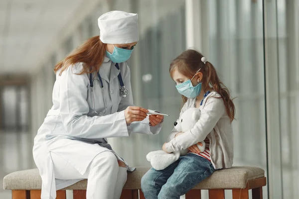 Лікар і дитина в захисних масках в лікарні — стокове фото