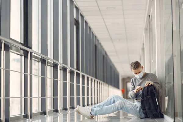 Man in a mask sitting in the hall of hospital — Stock Photo, Image