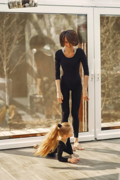 Vrouw met dochter is bezig met gymnastiek — Stockfoto