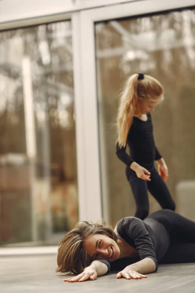 Vrouw met dochter is bezig met gymnastiek — Stockfoto