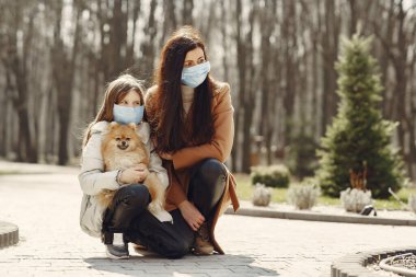Anne ve kızı maskelerle dışarı çıkıyorlar.