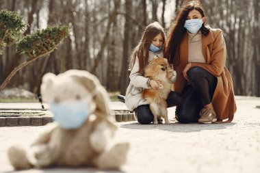 Anne ve kızı maskelerle dışarı çıkıyorlar.