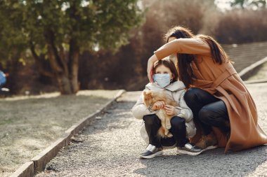 Anne ve kızı maskelerle dışarı çıkıyorlar.