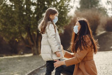 Anne ve kızı maskelerle dışarı çıkıyorlar.