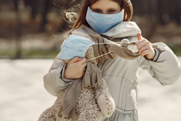 Criança pequena anda lá fora com uma máscara — Fotografia de Stock
